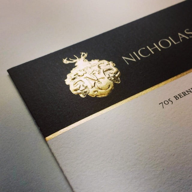 A black and gold corporate business card featuring the name Nicholas.